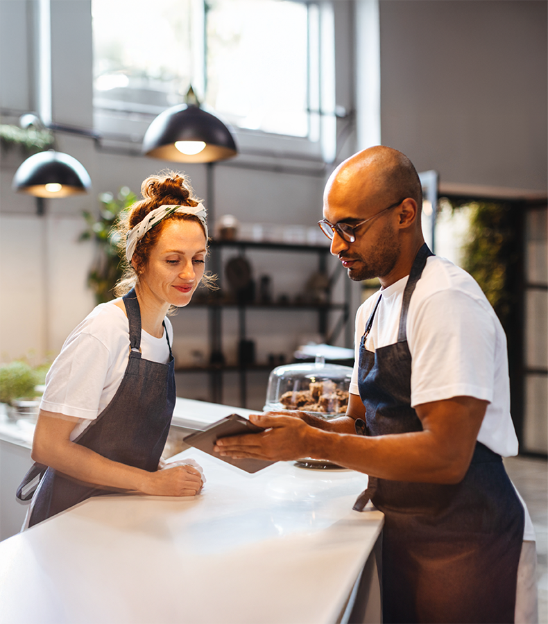 Hospitality staff using Elevate App Hospitality staff in a hotel coffee shop using the Elevate workforce management app, highlighting enterprise features for seamless operations.