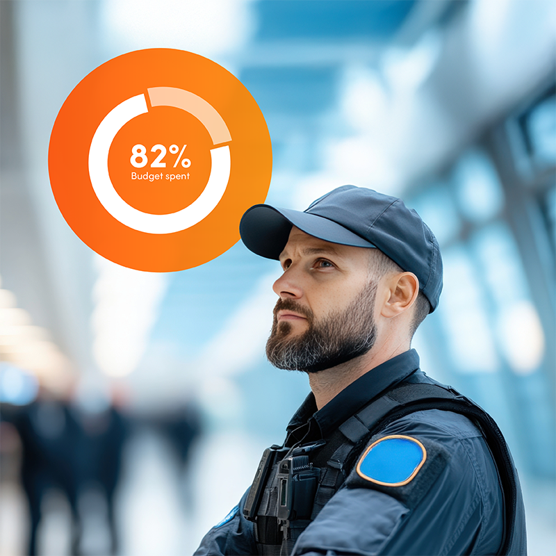 Security officer in office with budget spend graph, showing Elevate workforce management program ensures budget confidence for security labour.